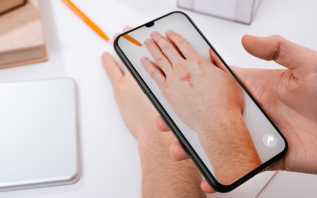 Mensch fotografiert seine Hand mit dem Smartphone
